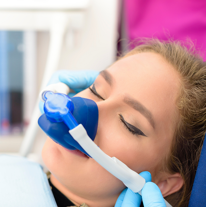 Young woman in the dental chair with a nitrous oxide mask over her nose