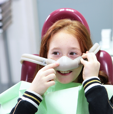 Young girl wearing a nitrous oxide mask