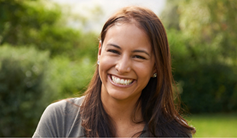 Young brunette woman grinning outdoors