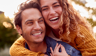 Young couple laughing together in the sunlight