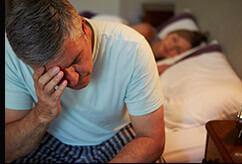 Frustrated man can't sleep holding head