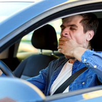 Man yawns while driving