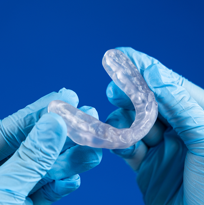 Dentist holding a clear occlusal splint tray