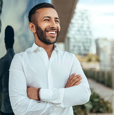 Man in a white collared shirt smiling outdoors