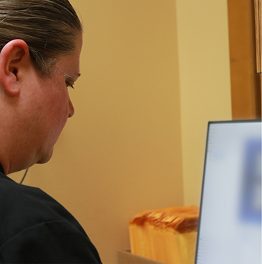 Dental team member looking at a computer screen