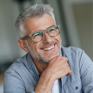 Man with gray hair and glasses smiling