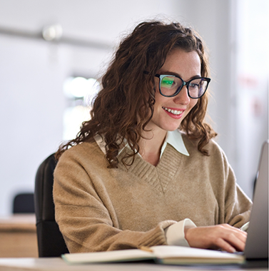 Smiling woman using a computer at a desk