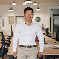 a smiling person resting on a desk