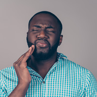 a man holding his mouth in pain