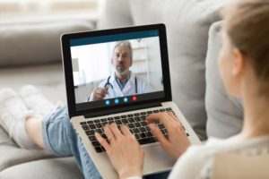 A dentist in Bellingham speaking to a patient via laptop.