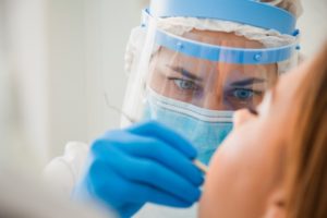 A protected dentist in Bellingham performing a patient exam.