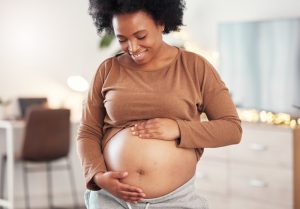 a pregnant woman smiling with dentures