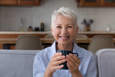 Senior woman smiling on a couch.