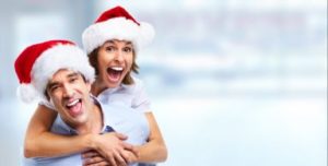 Smiling couple wearing Santa hats