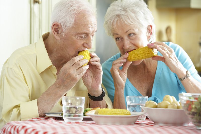 Older couple eating summer foods.