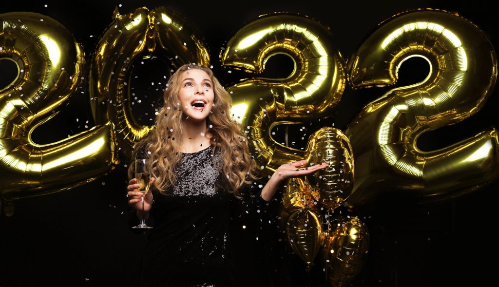 person smiling in front of 2022 balloons